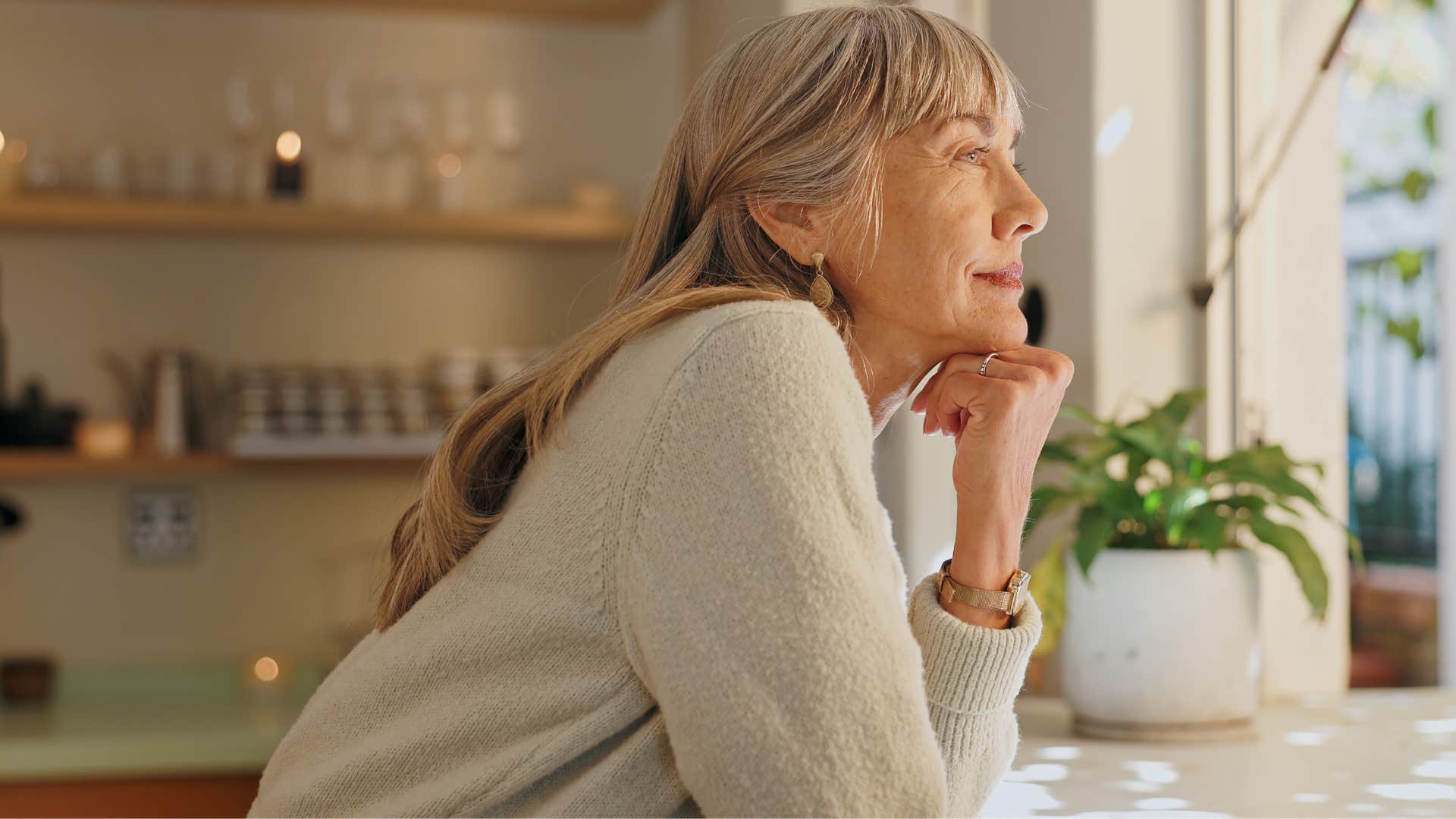 self-aware woman smiling in her kitchen alone
