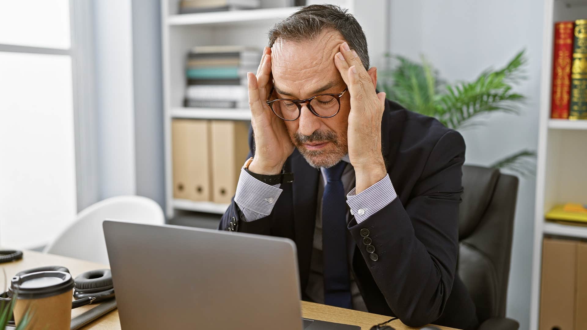 Man who's identity was always tied to other things sitting at work.