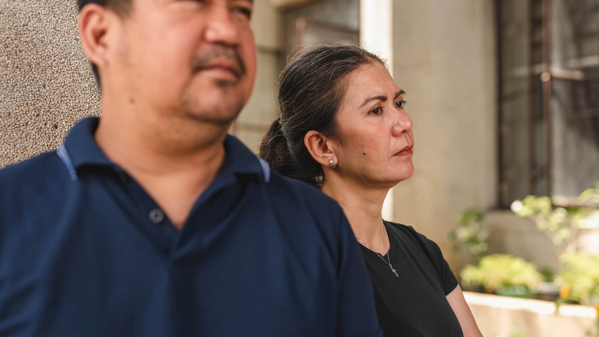 Woman who's stayed in unfulfilling relationships standing by her husband.