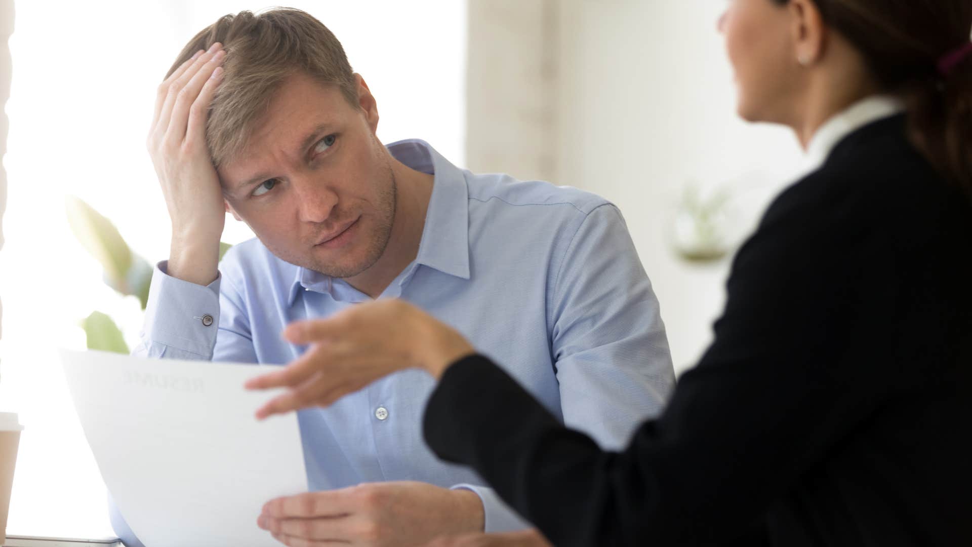 embarrassed man trying to change the subject with his colleague