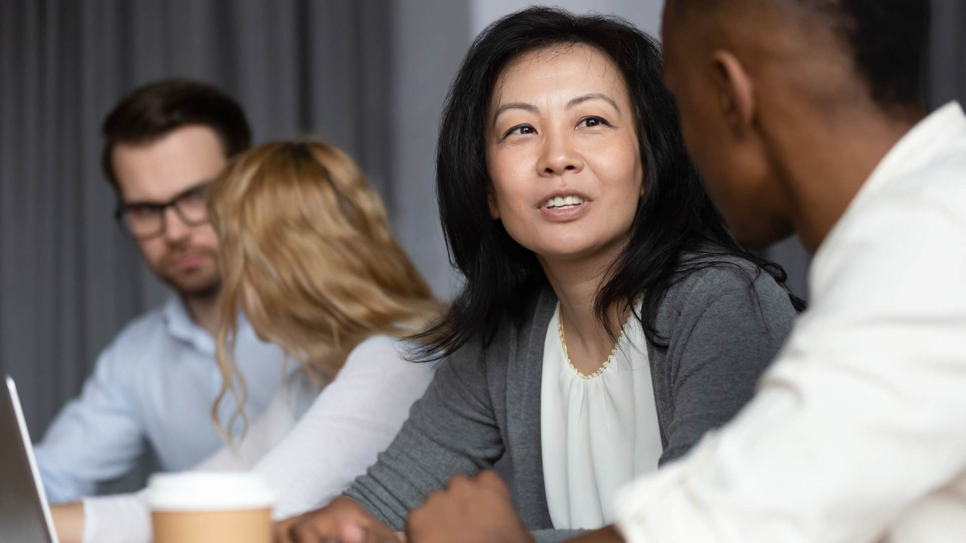 woman giving someone else a compliment in a work meeting