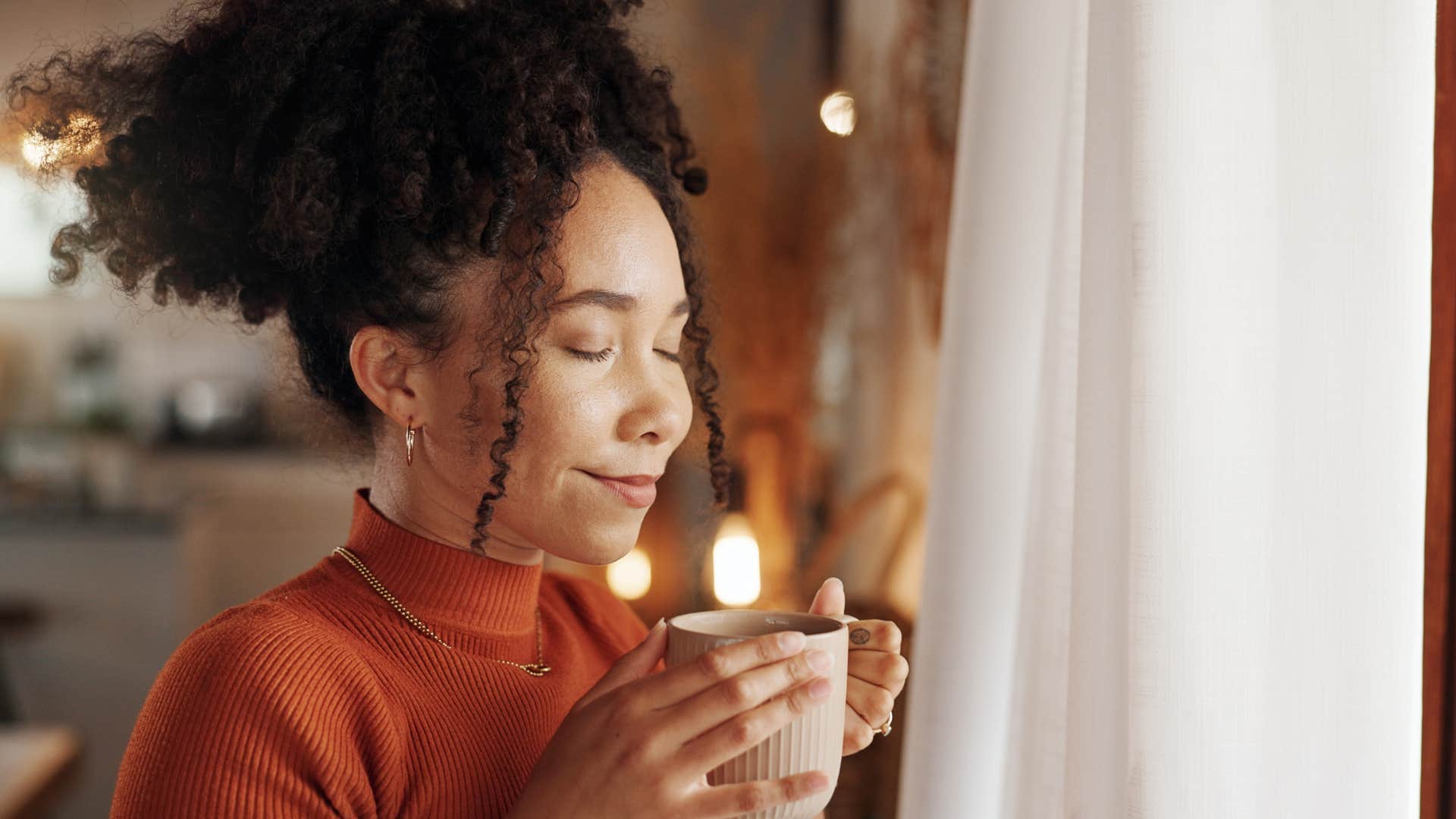 comfortable with being different people who prefer tea over coffee usually have these surprisingly grounded personality traits Woman who's comfortable with being different drinking tea.