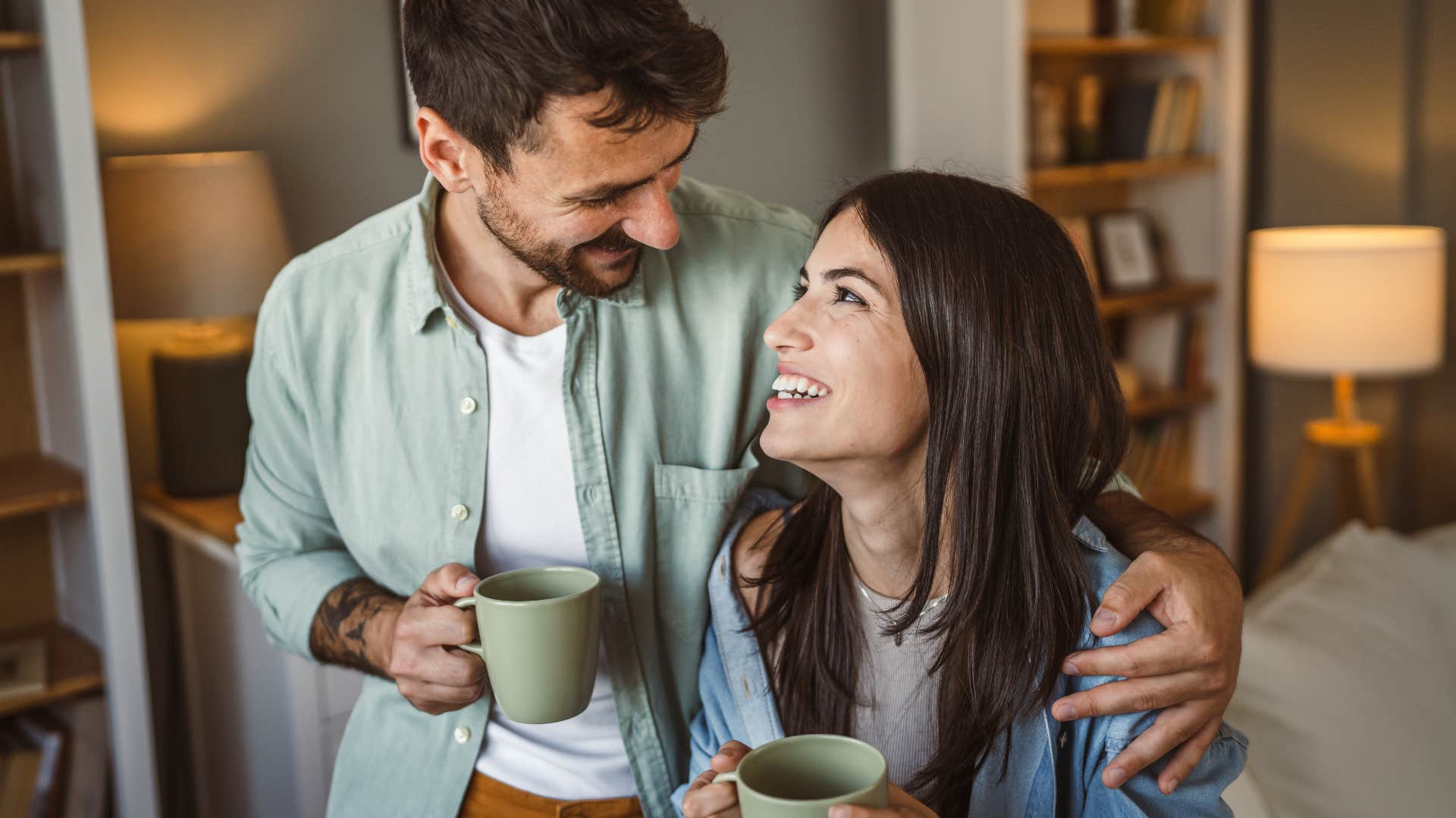 thoughtful and intentional people who prefer tea over coffee usually have these surprisingly grounded personality traits Thoughtful and intentional couple smiling and drinking tea.