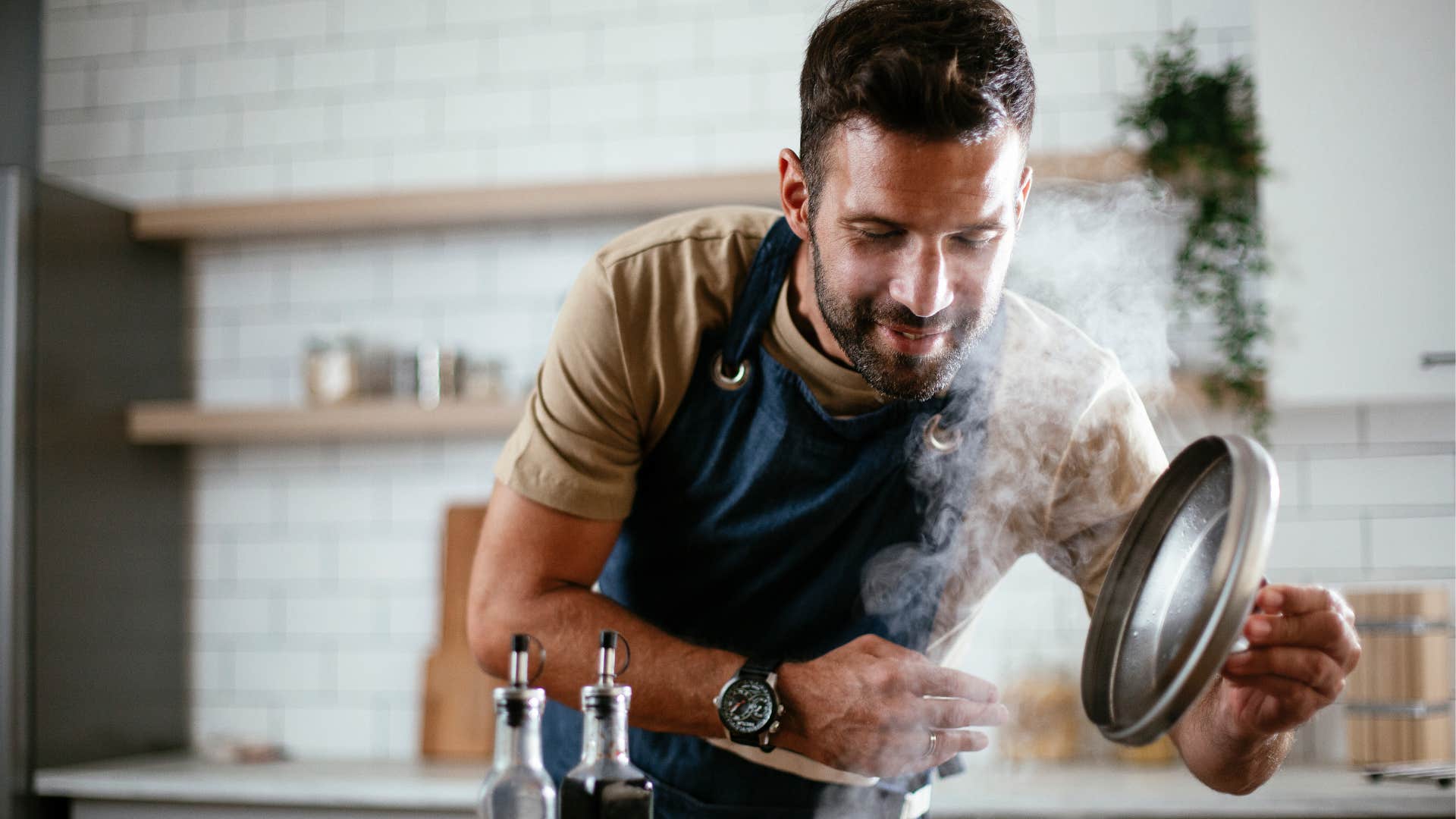 happy man cooking for himself at home