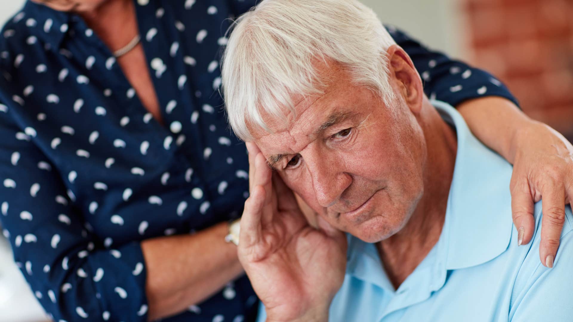 man saying we'll get through it next to his unhappy wife