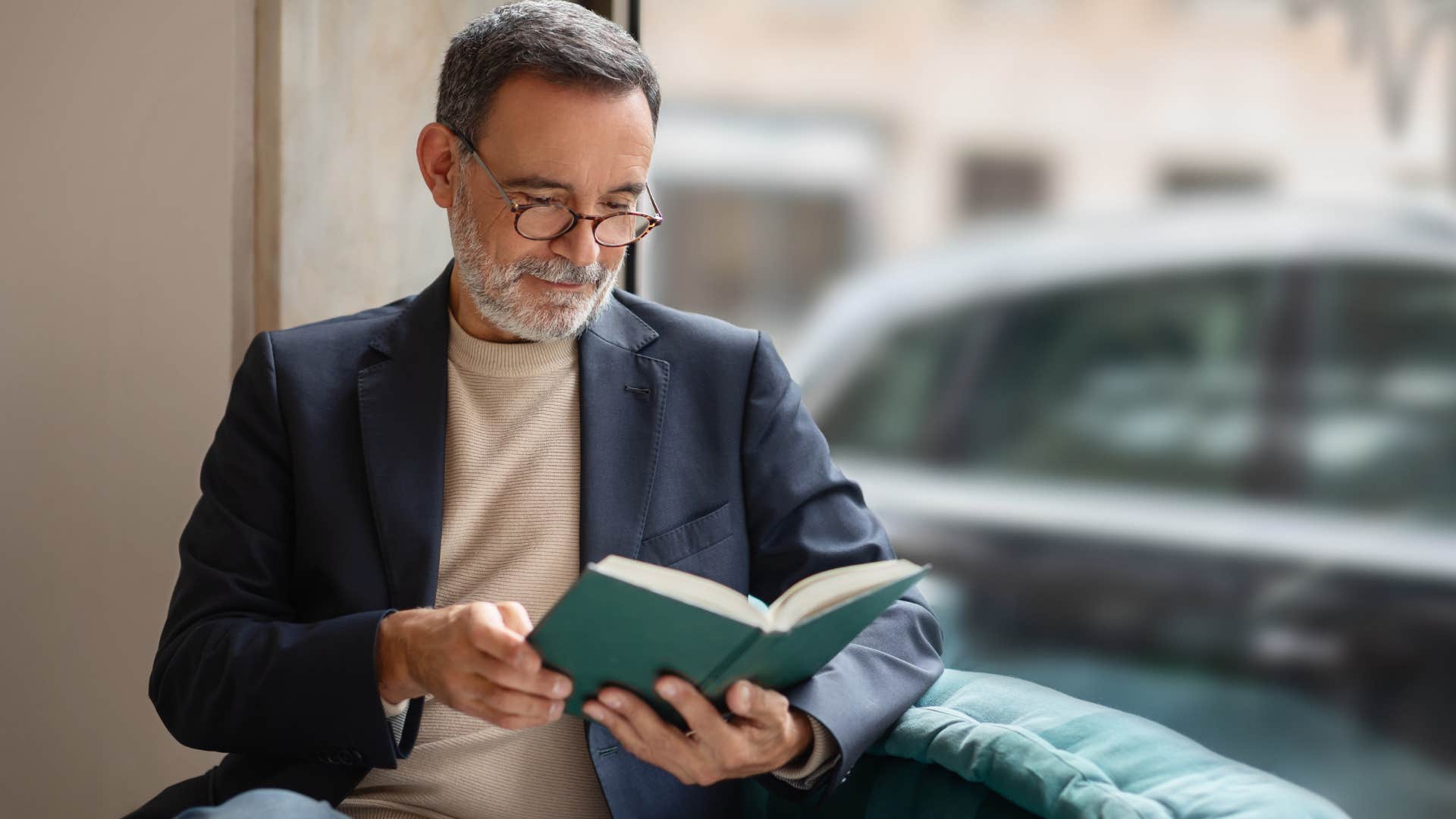 self-disciplined people who still read physical books instead of scrolling usually have these rare personality traits self-disciplined man reading a book outside
