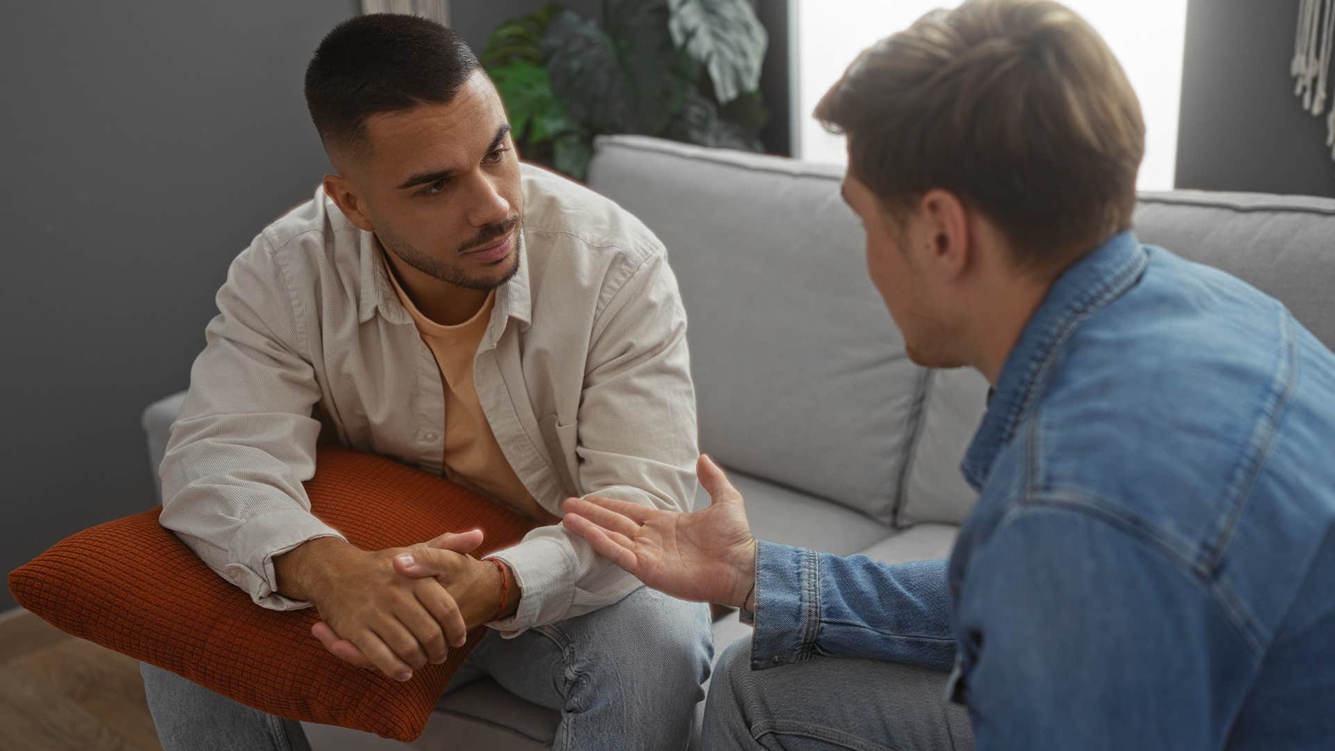 Man saying "I didn't mean it like that" to a friend.