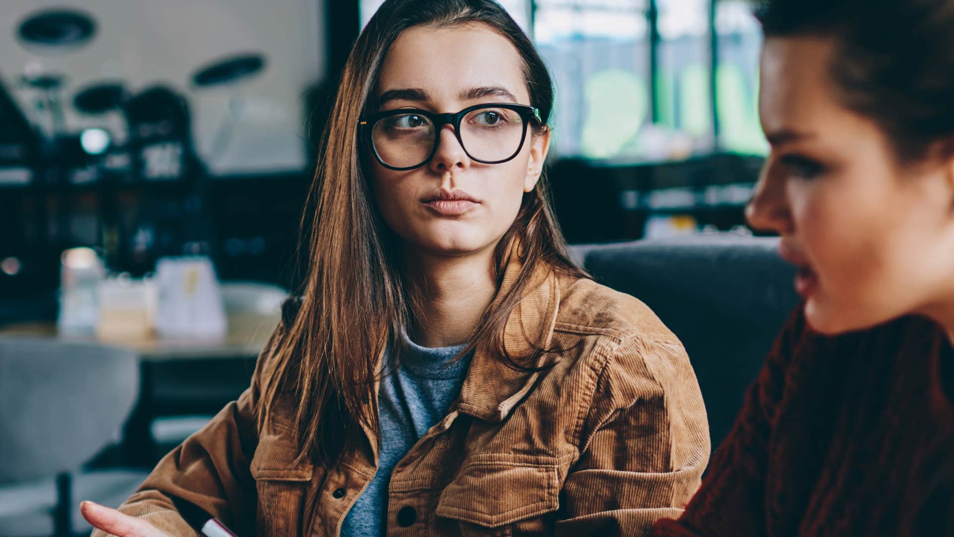 focused woman intimidated by friend speaking