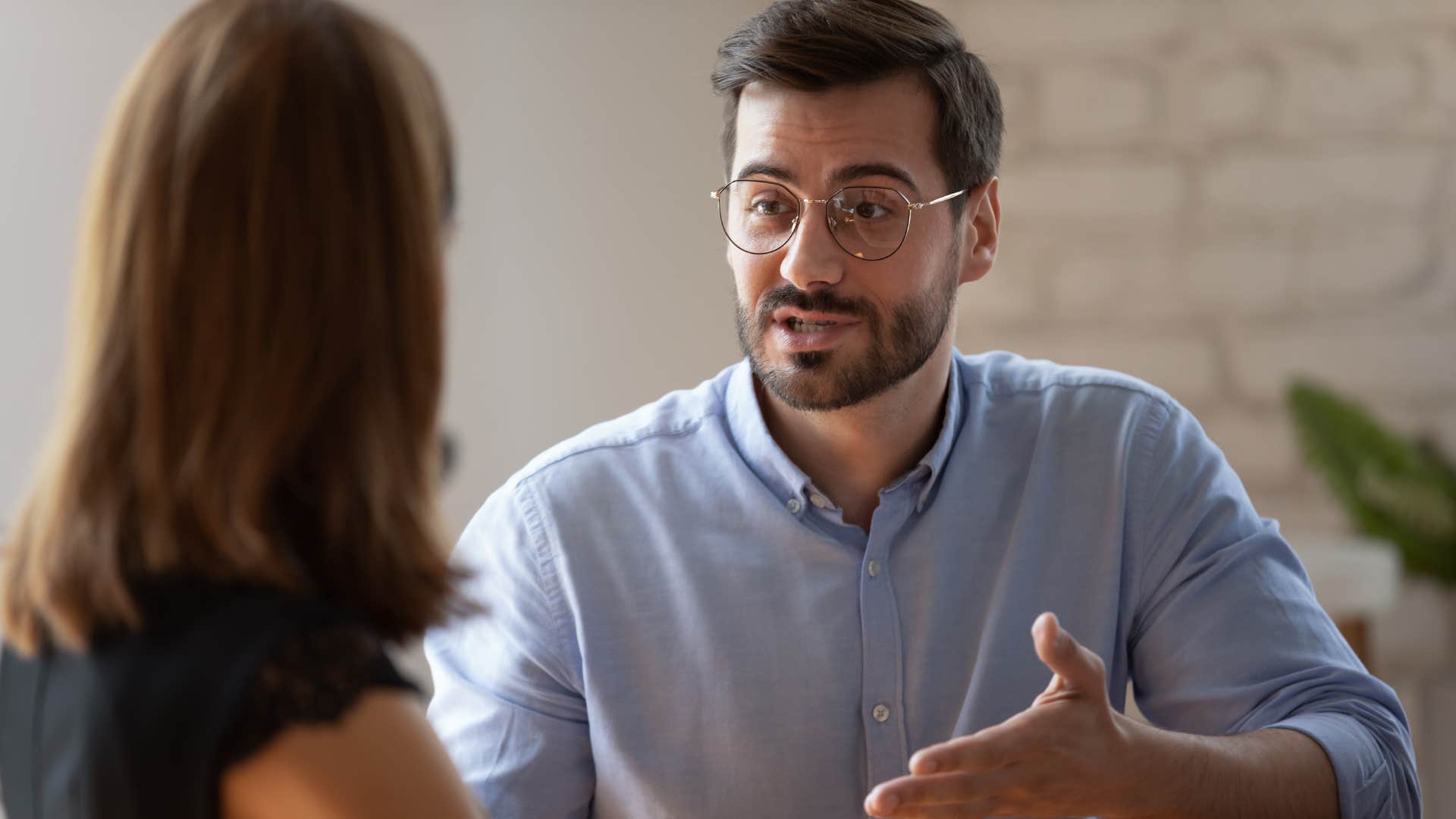 man talking to work colleague saying shes hard to read
