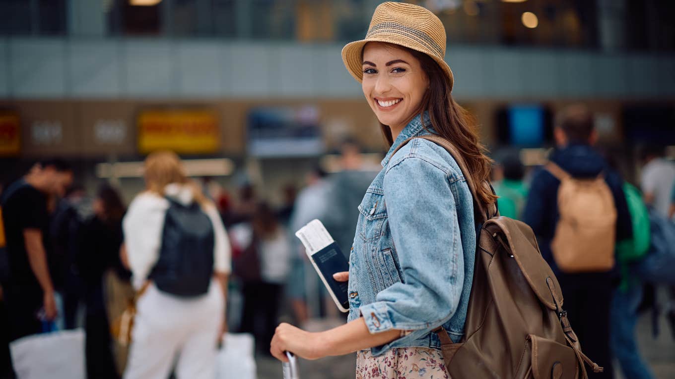 People Who Wait Until The Very Last Minute To Board A Flight Usually Display These Traits smiling woman waiting to board a plane at the airport