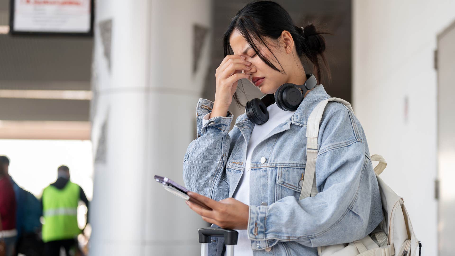 woman who dislikes small talk standing alone in an airport