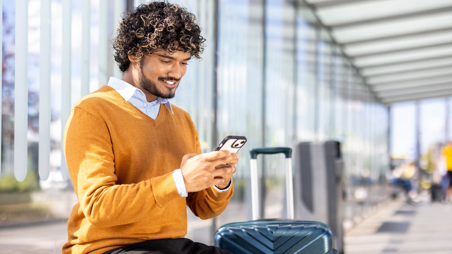 man who's a seasoned traveler sitting in an airport waiting