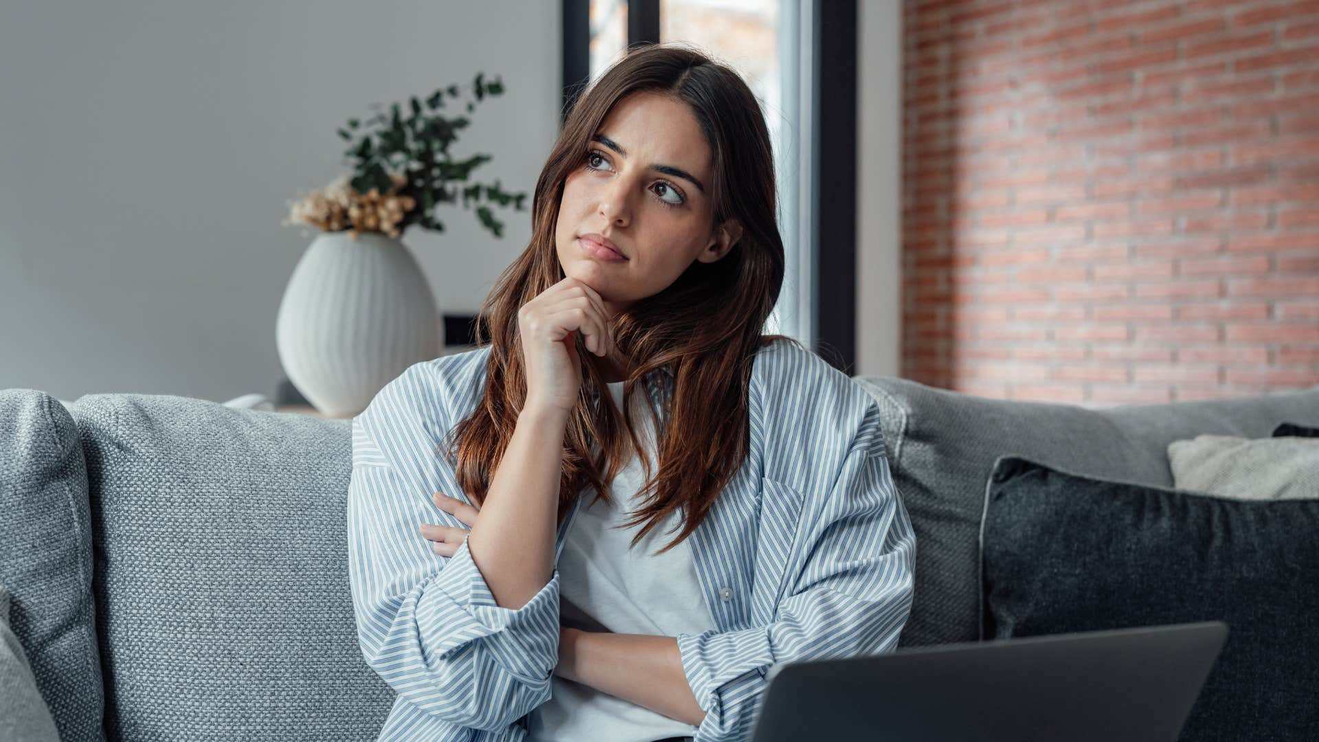 phrases brilliant people use instead of i knew that already that rings a bell woman in white shirt thinking that rings a bell as she sits with laptop on lap