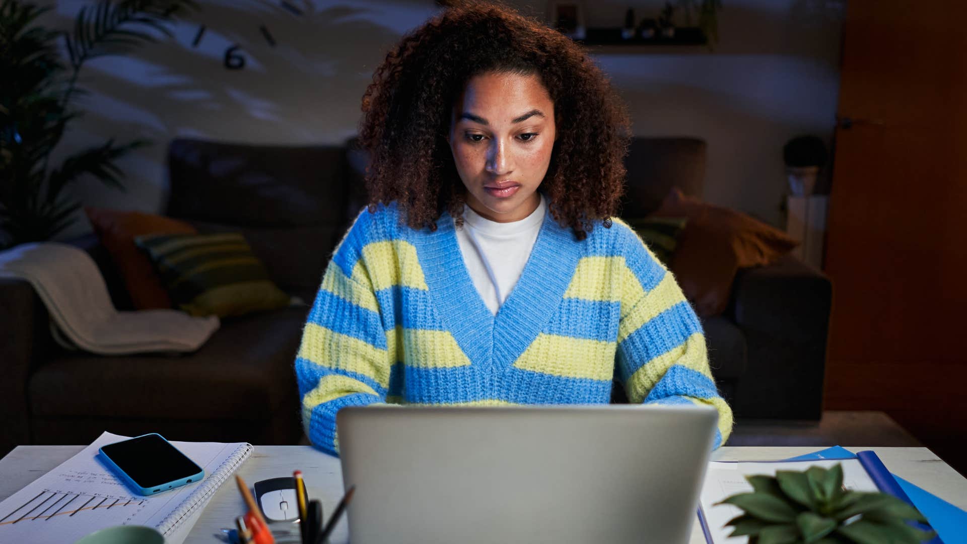 gen z woman who doesn't have job security working on her laptop