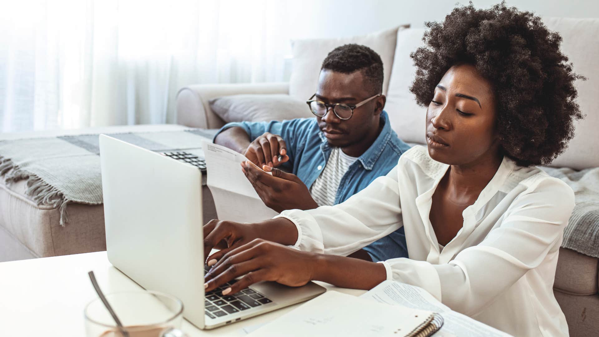 gen z couple looking sad doing bills and thinking about wealth inequality