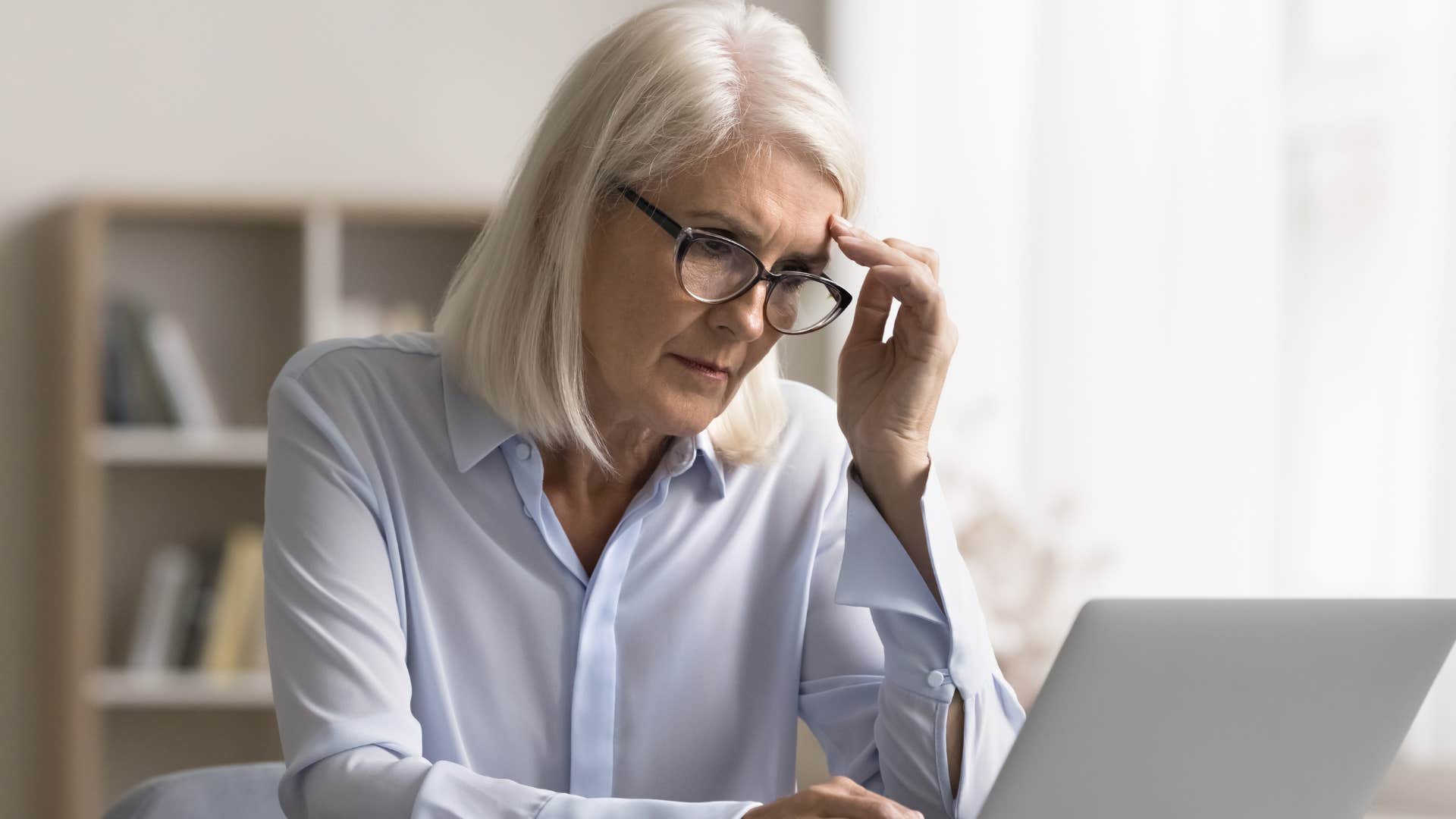 woman who's burnt out from work looking at her laptop
