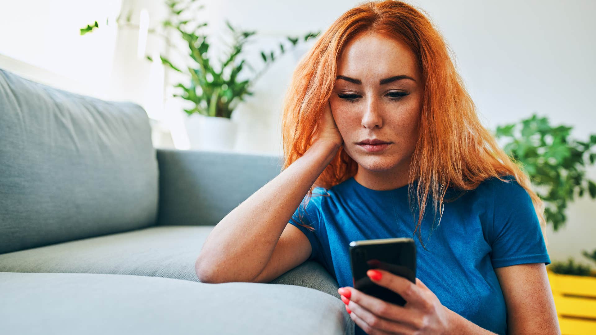 depressed woman looking at her phone