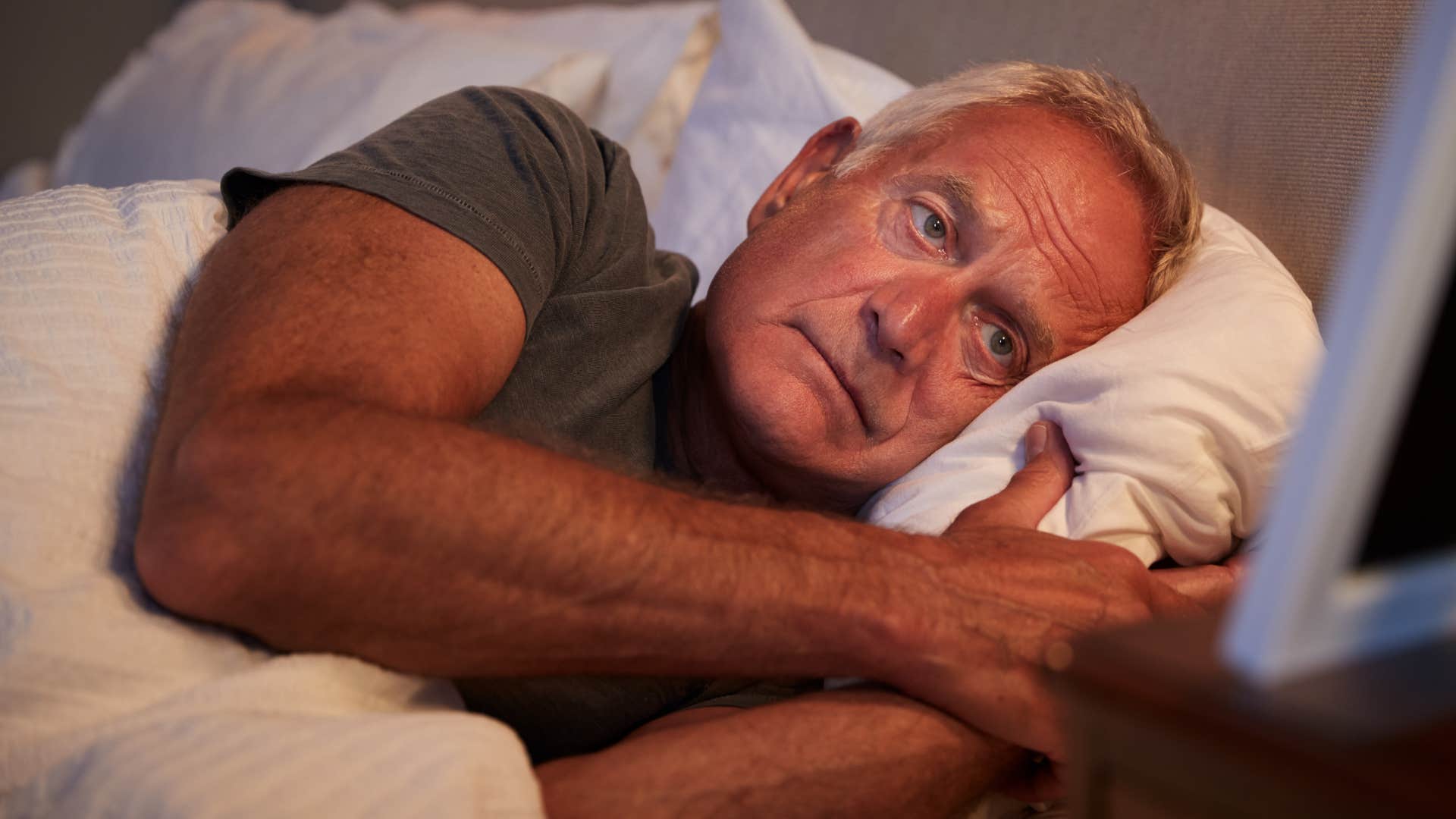 man who's stuck in survival mode laying in bed alone