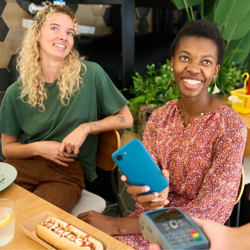 woman paying for her friend's meal