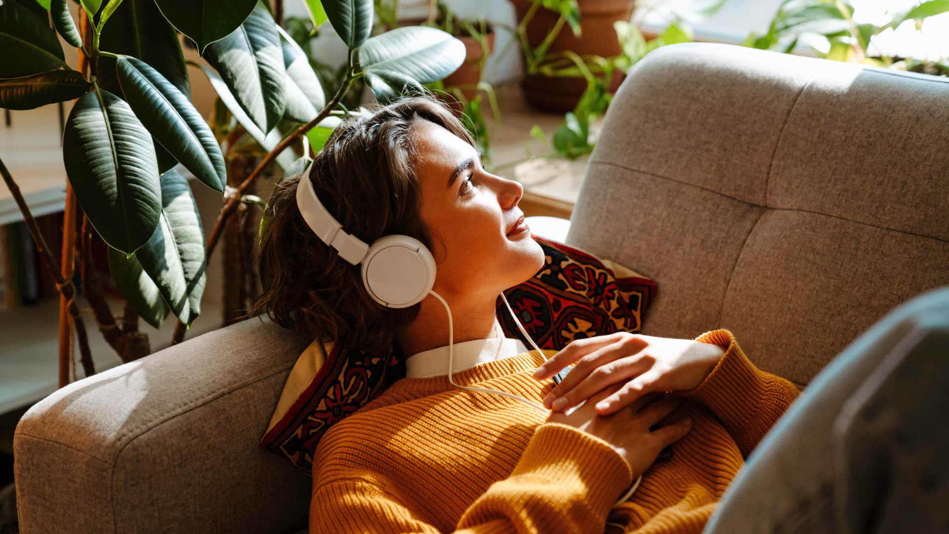 woman in orange sweater being easily affected by music and art