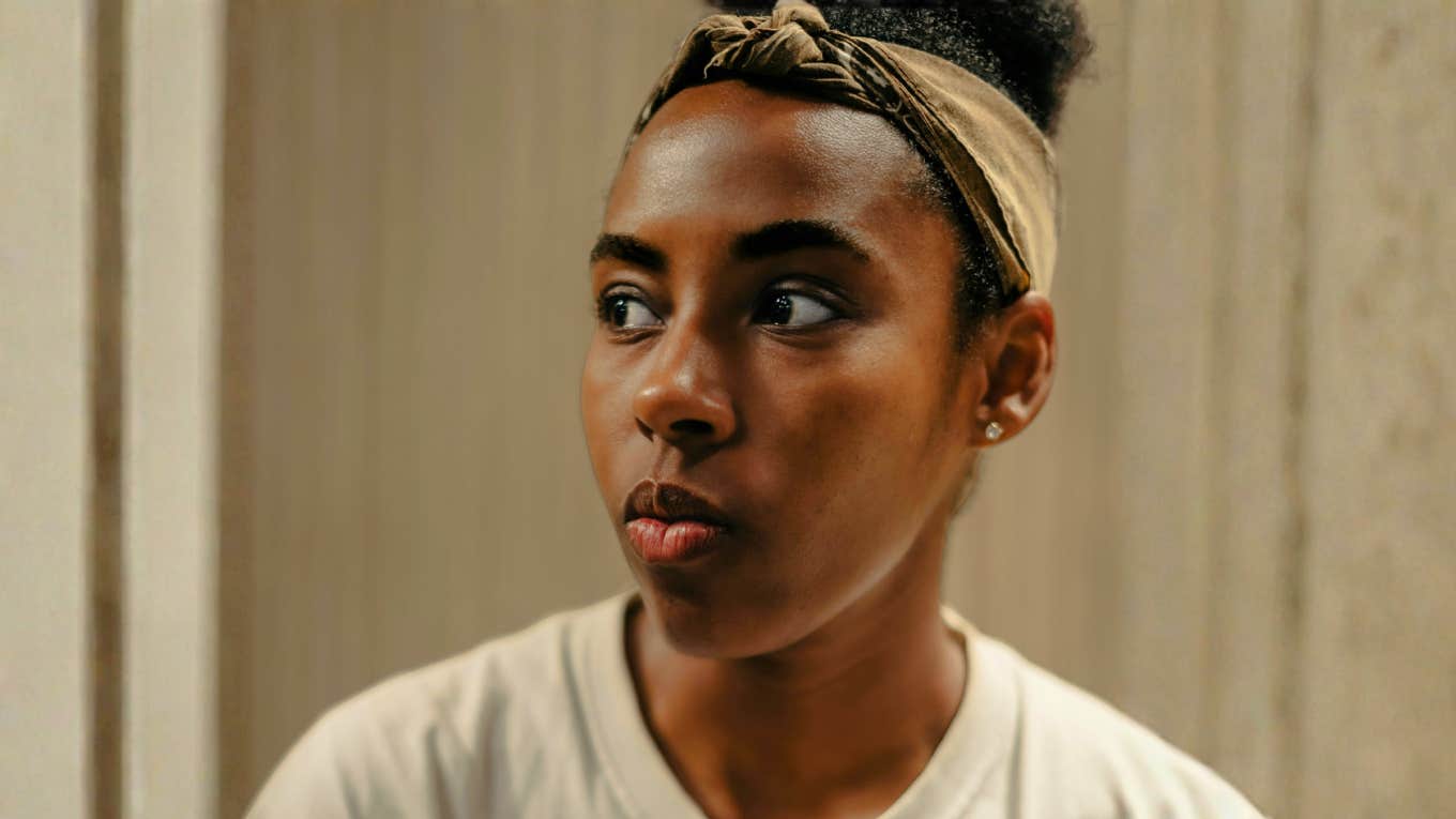 Woman with stoic expression looking off to the side, illustrating signs you’re always playing therapist to someone who won’t change.