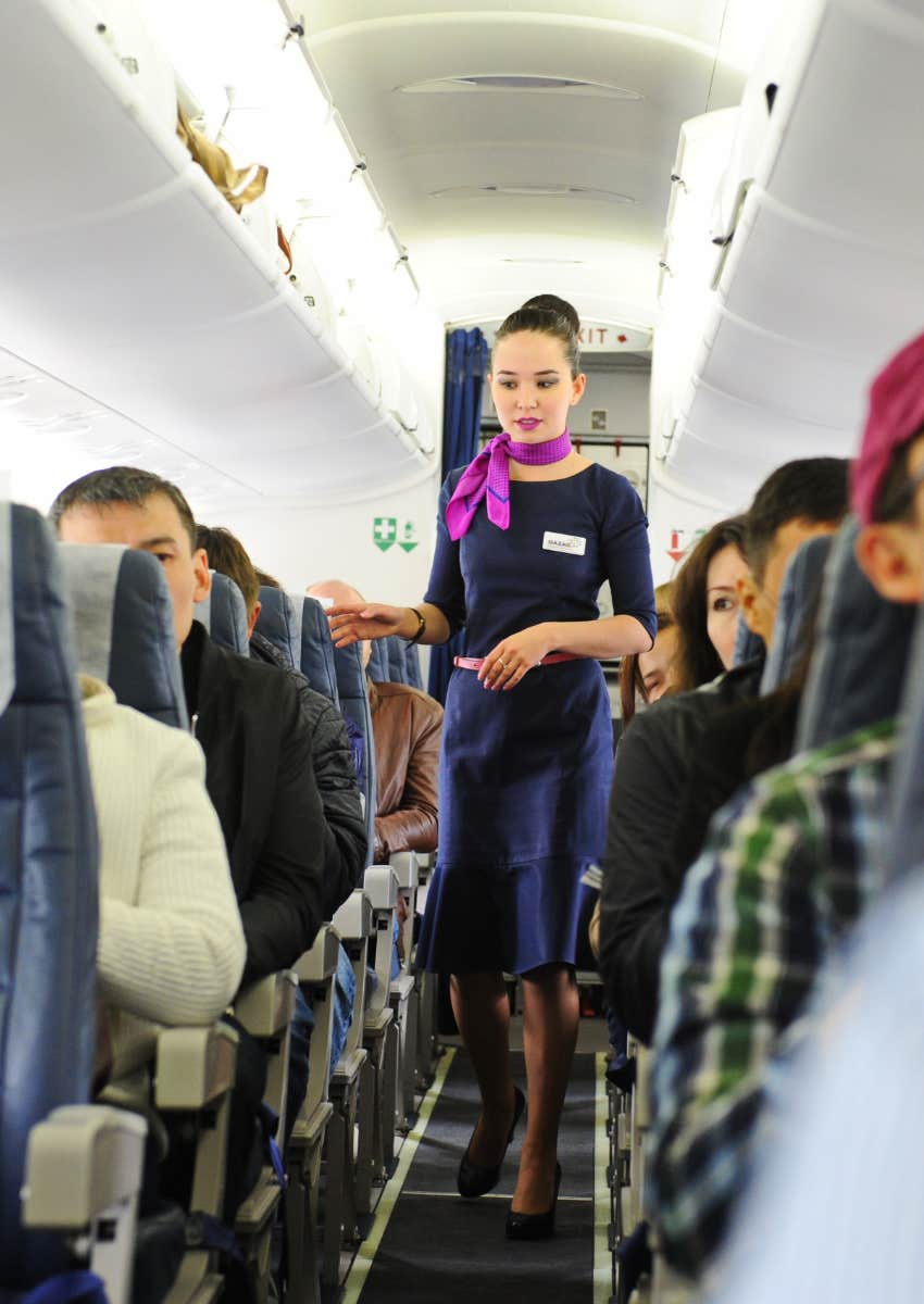 flight attendant walking down the aisle of a plane