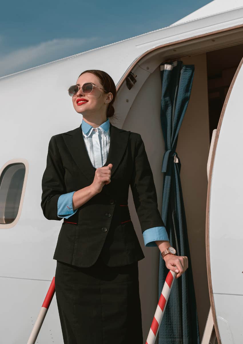 flight attendant standing at the door of a plane