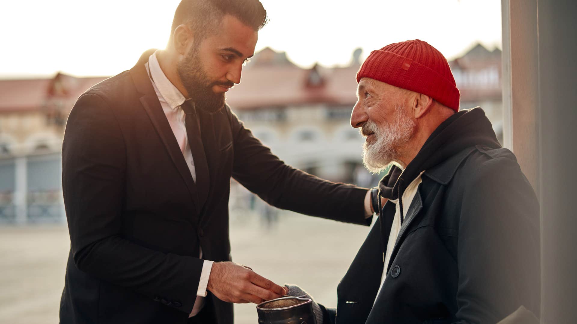 man being generous giving money to unhoused man