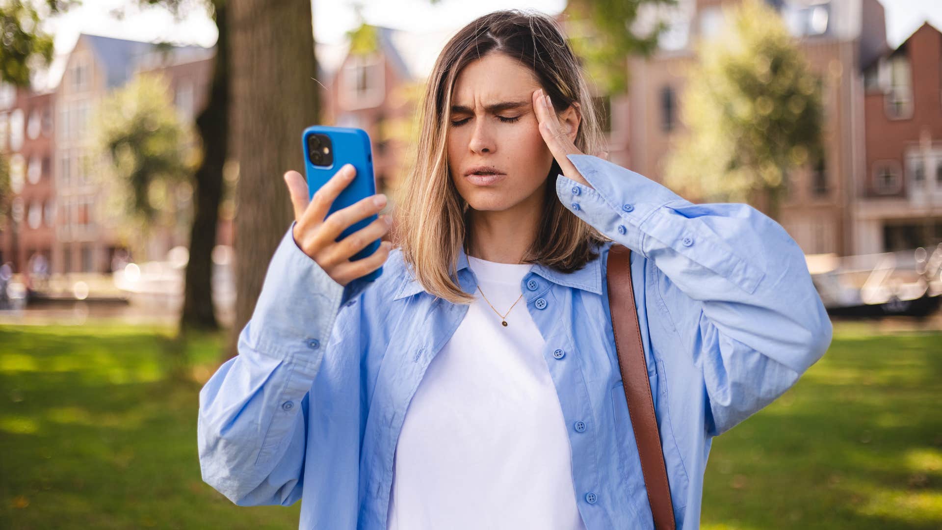 woman looking at phone confused that friend deleted their social media posts
