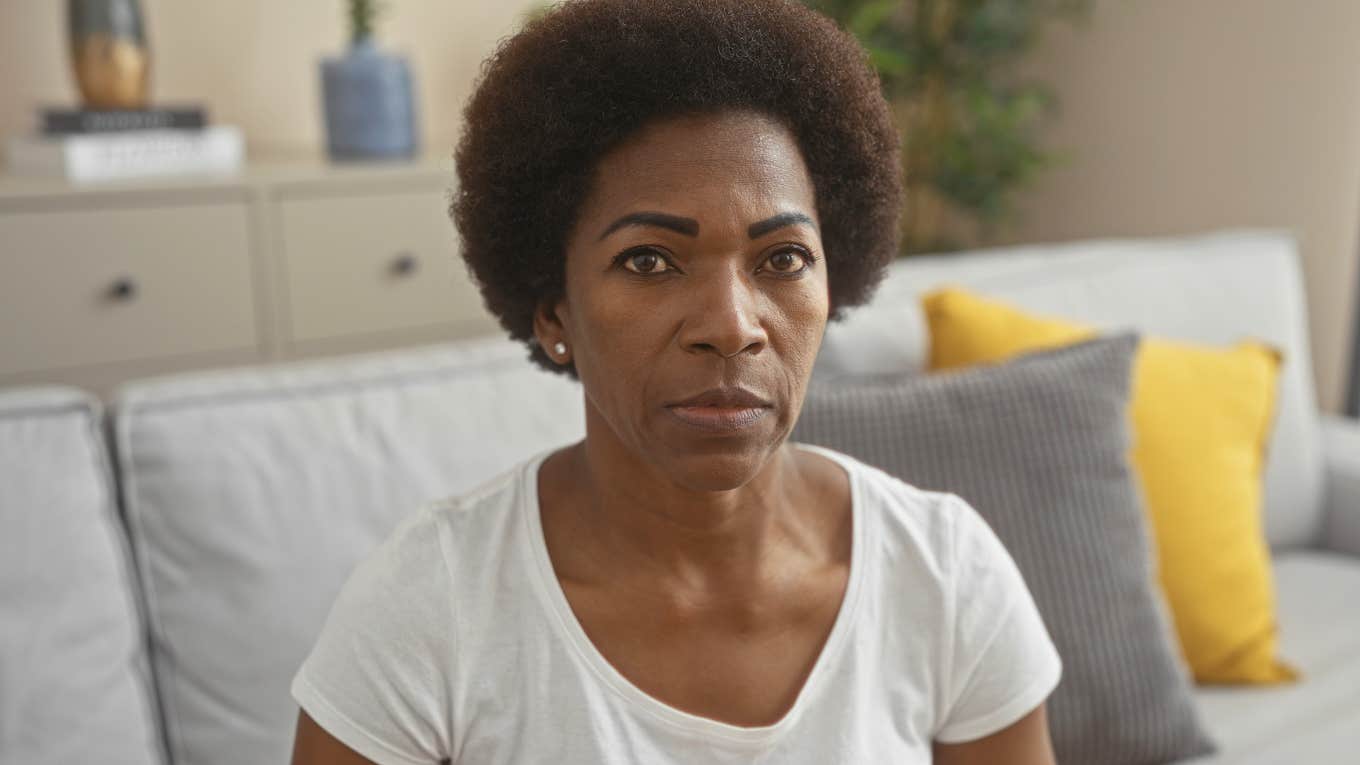 stressed sad serious woman sitting on her couch at home