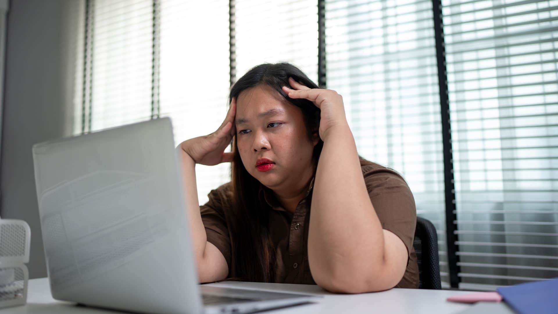 woman who is getting chronic headaches as she is overworking herself