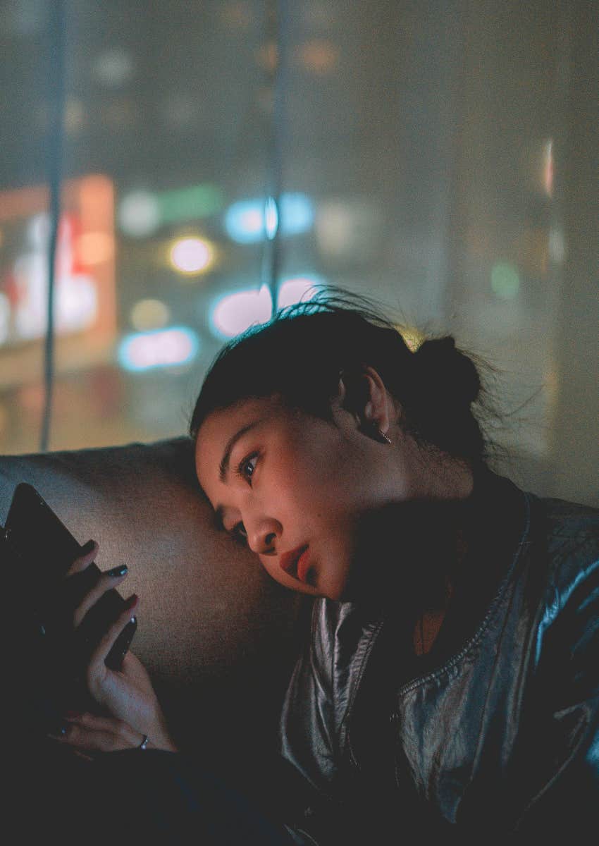 lonely woman looking at her phone