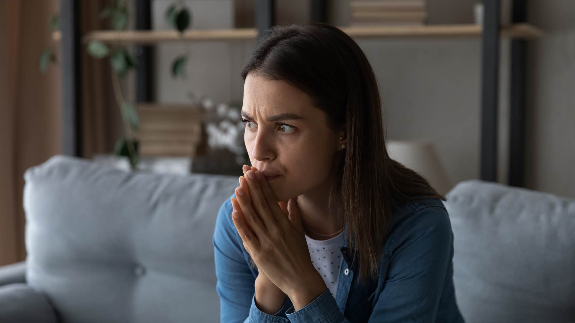 stressed out woman sitting home worrying