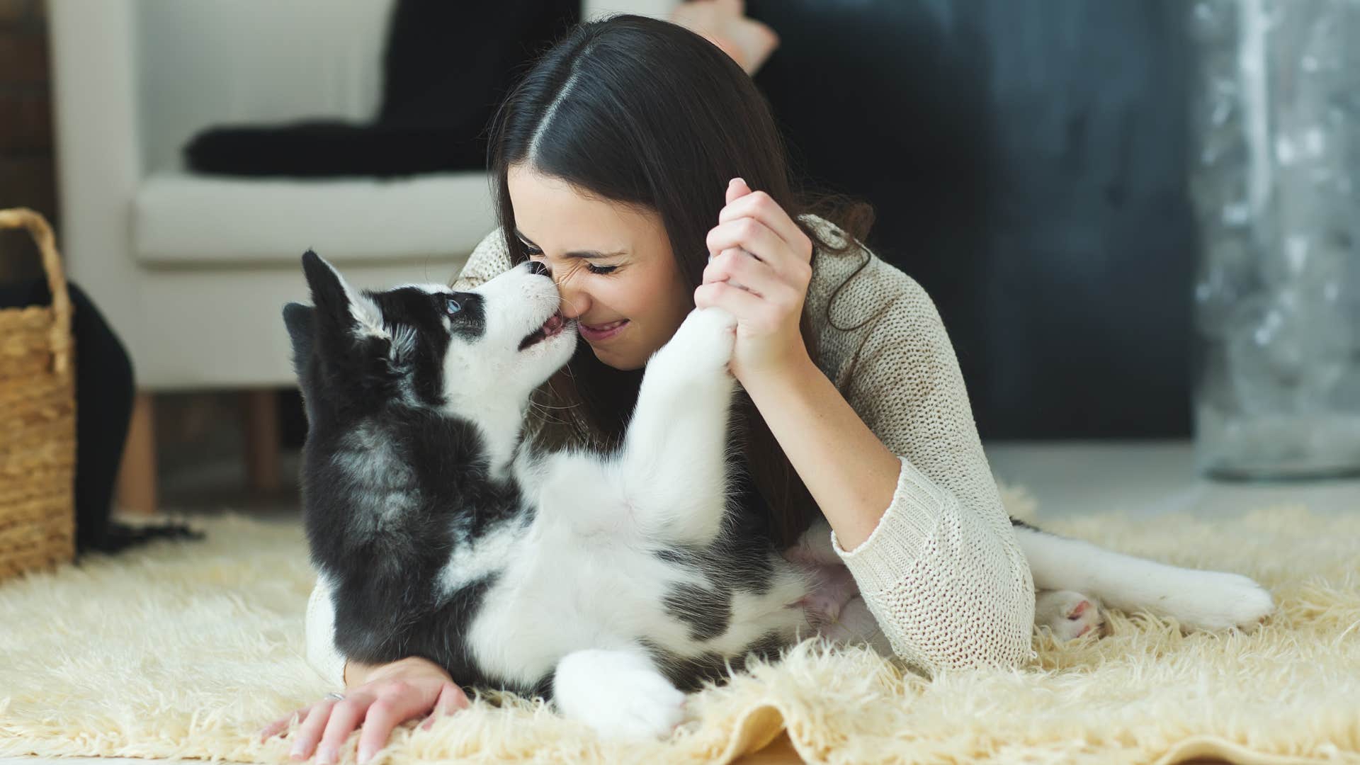 woman playing around with dog sitting on floor