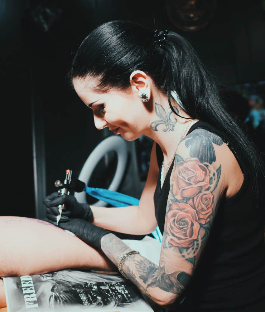 tattoo artist giving tourist a tattoo