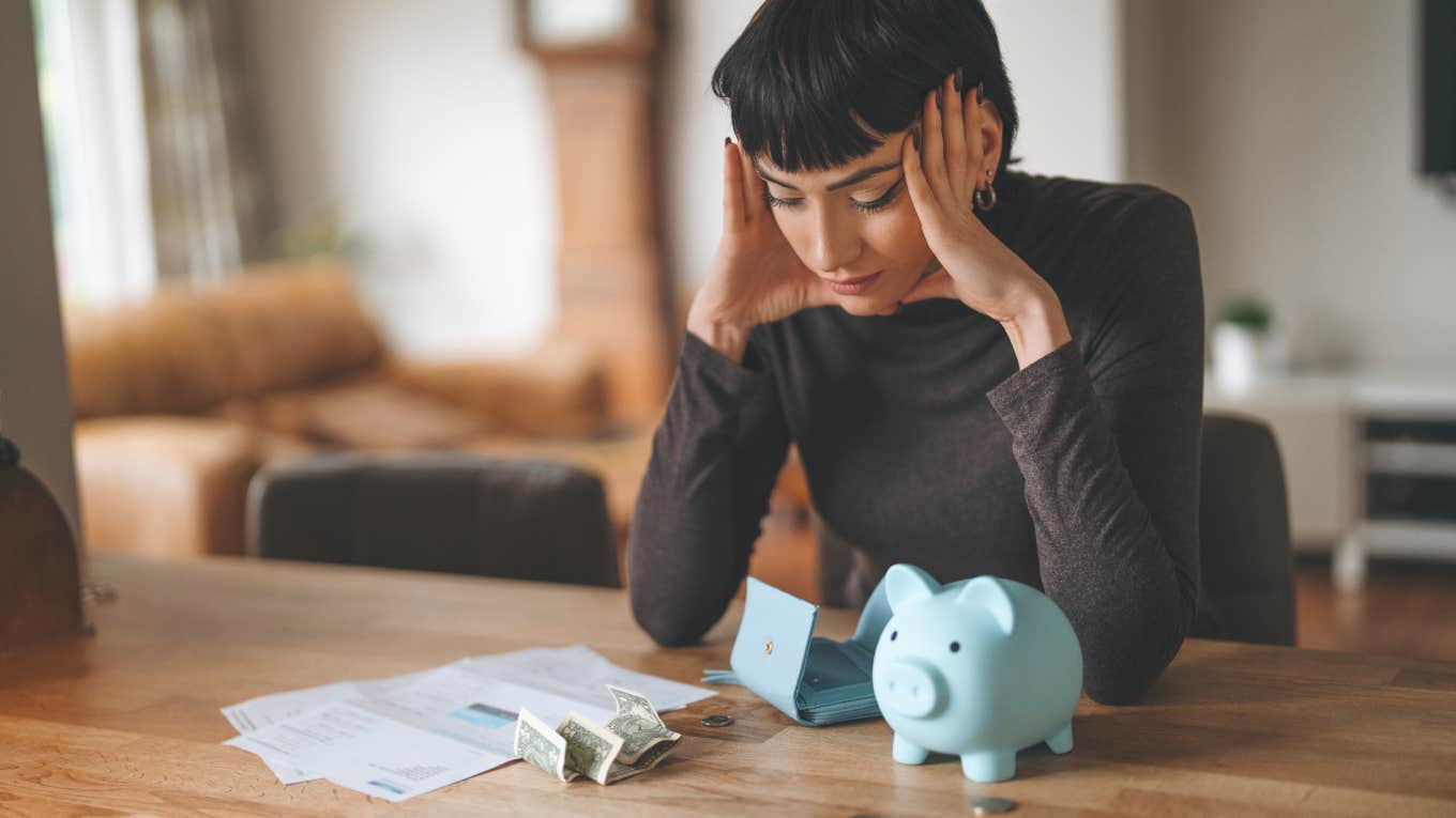 The Cost Of Living Is Too High Right Now To Let Yourself Be Ashamed Of These 5 Things woman sitting at kitchen table stressed out over finances