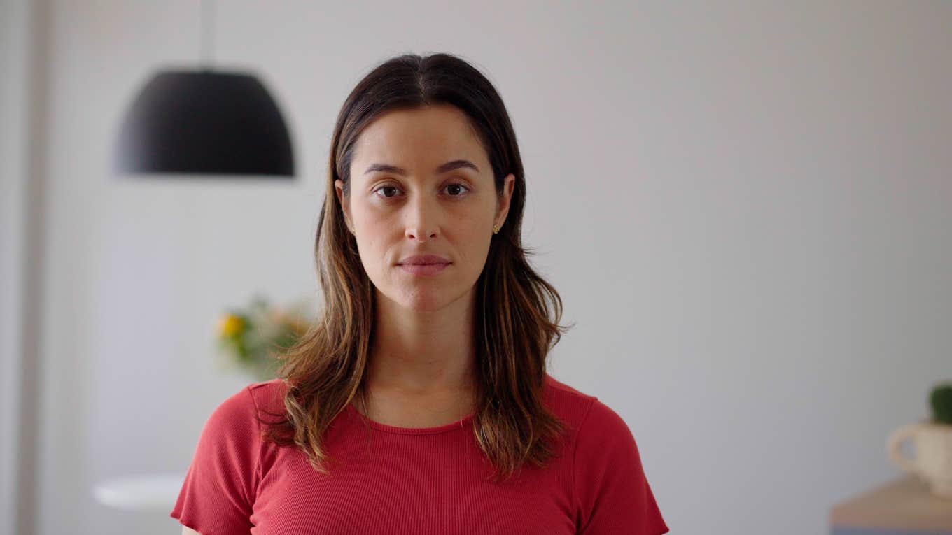 serious woman standing at home looking at camera