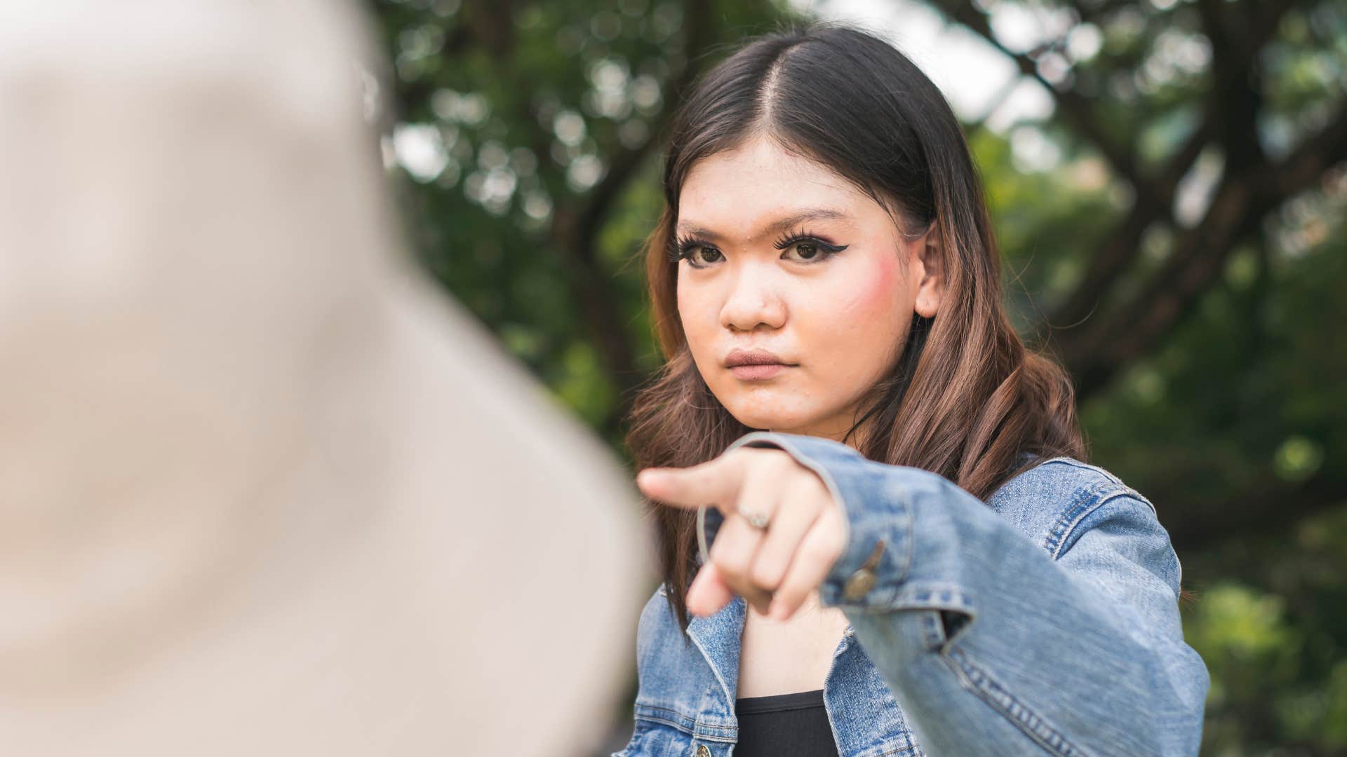 woman pointing finger blaming others for her unhappiness