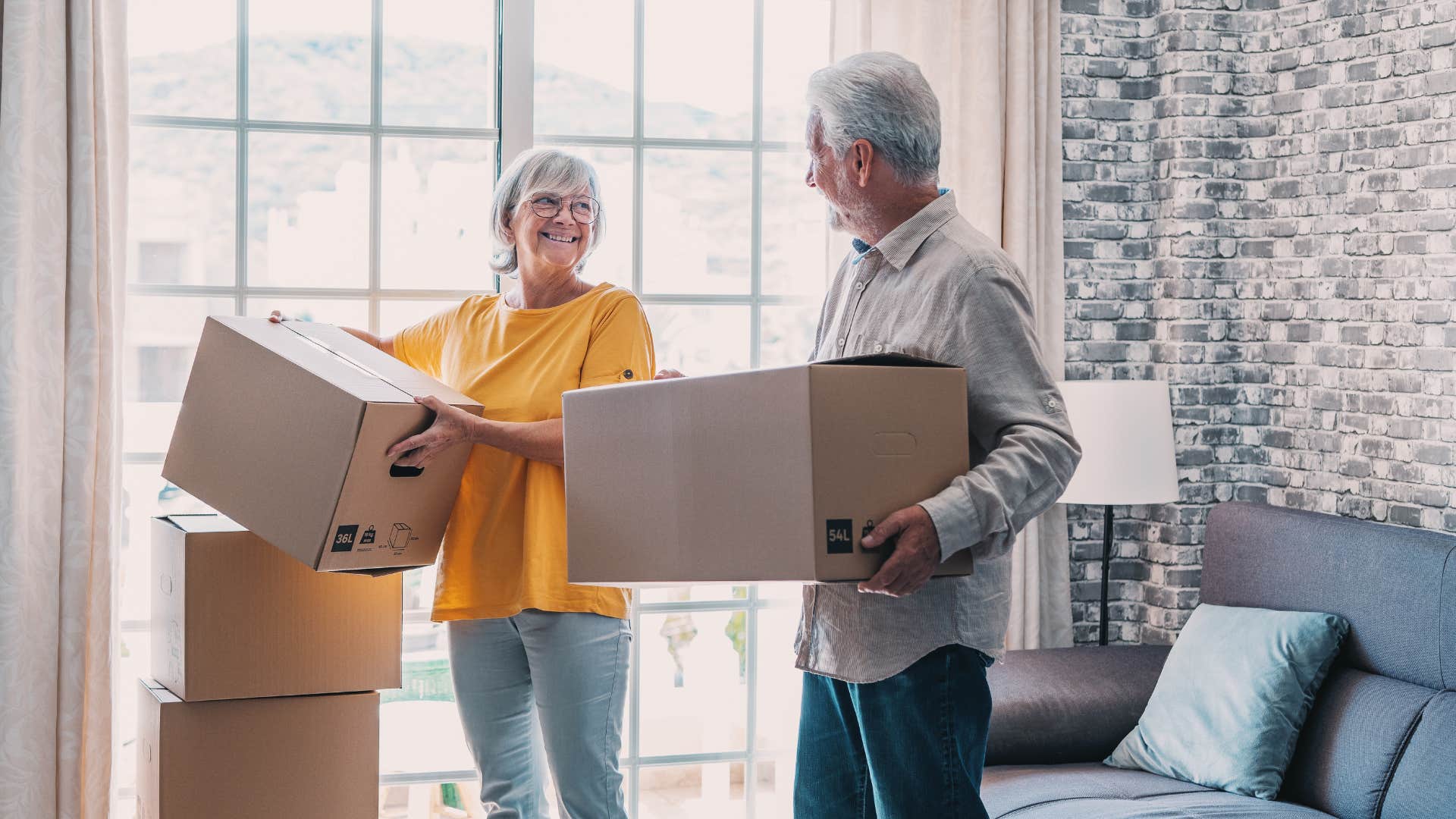 couple moving boxes of just in case items as they smile at each other