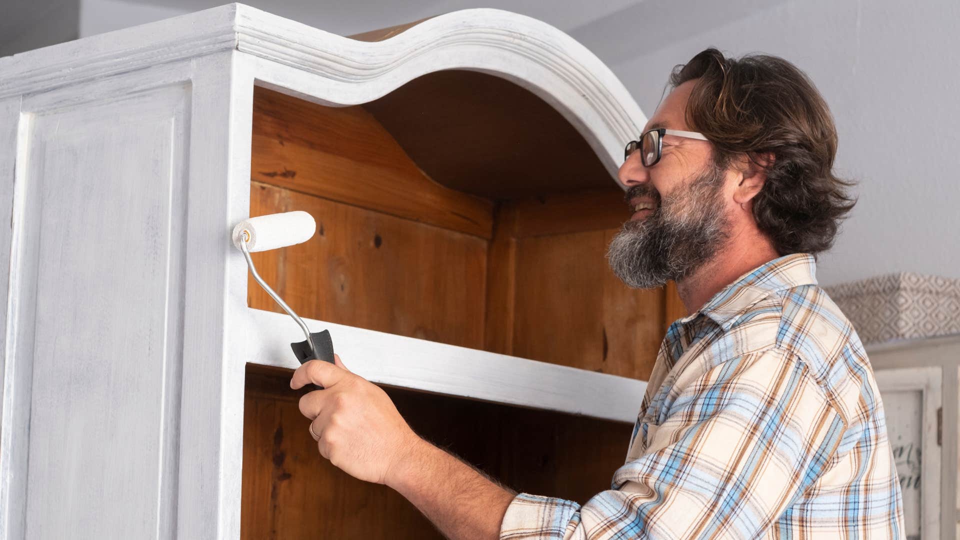 man painting over old furniture that was in bad condition 