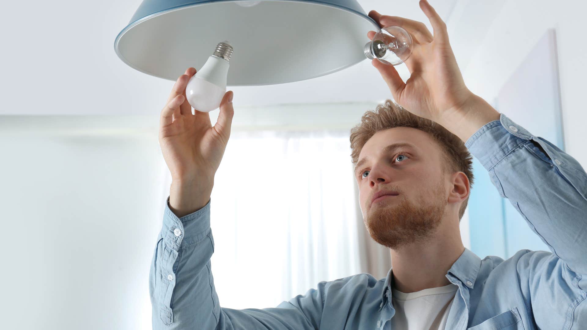 man changing burnt-out light bulbs at home