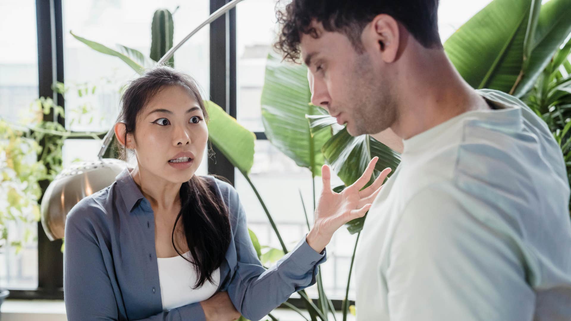 woman in gray shirt always takes things too seriously as she talks to man