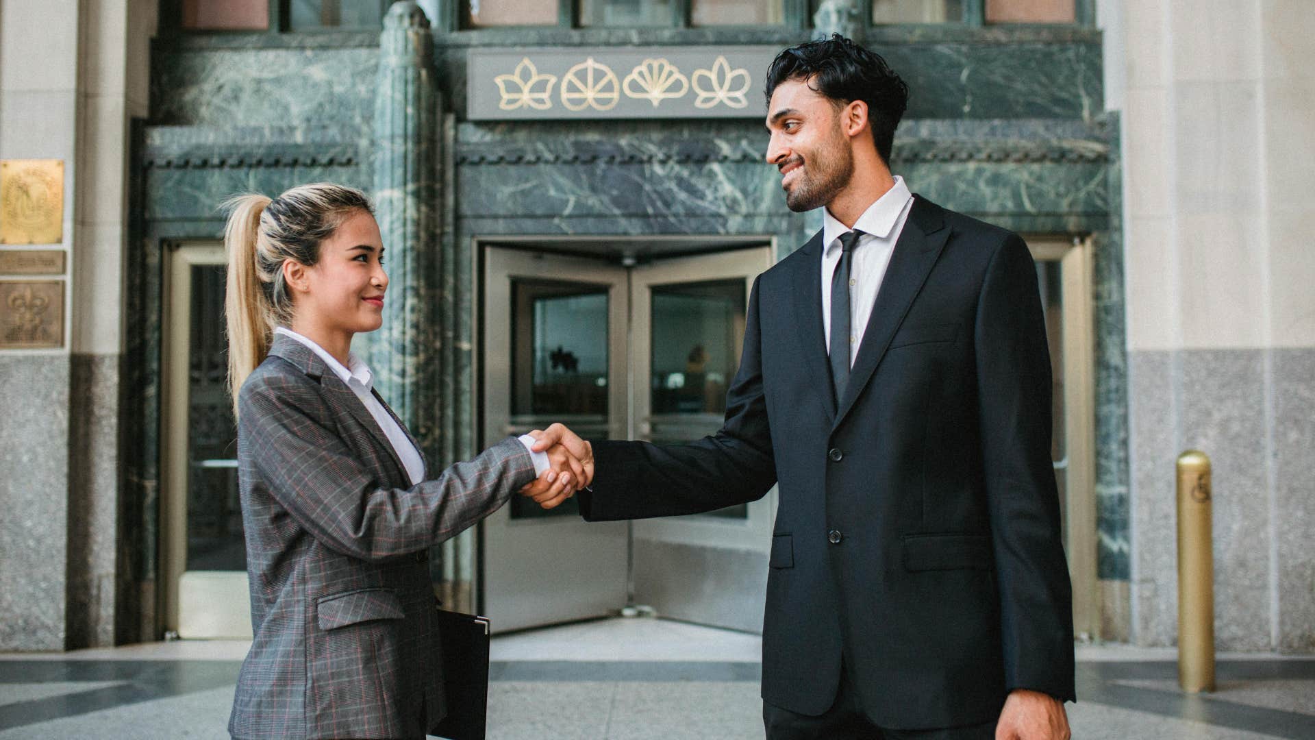 man and woman shaking hands as she readily agrees to everything