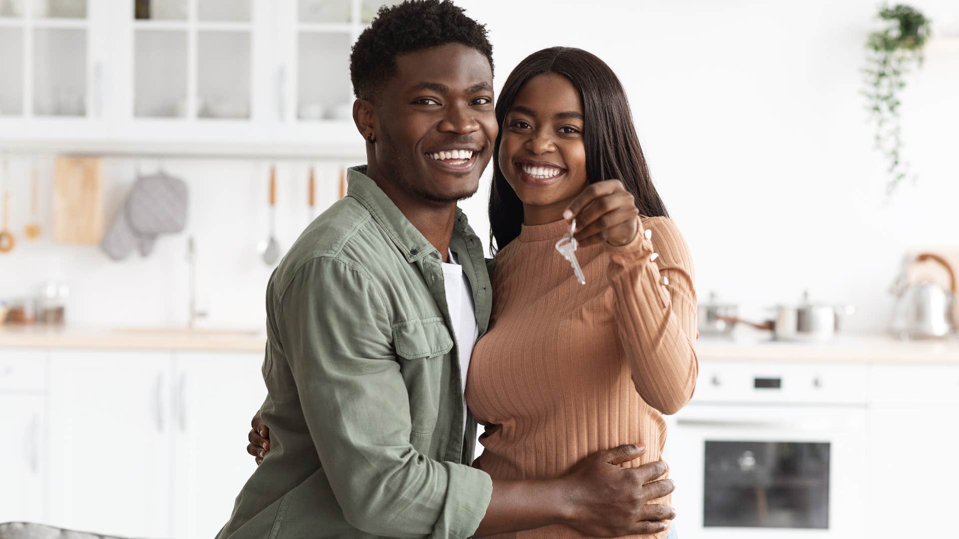millennial couple showing off new homeownership