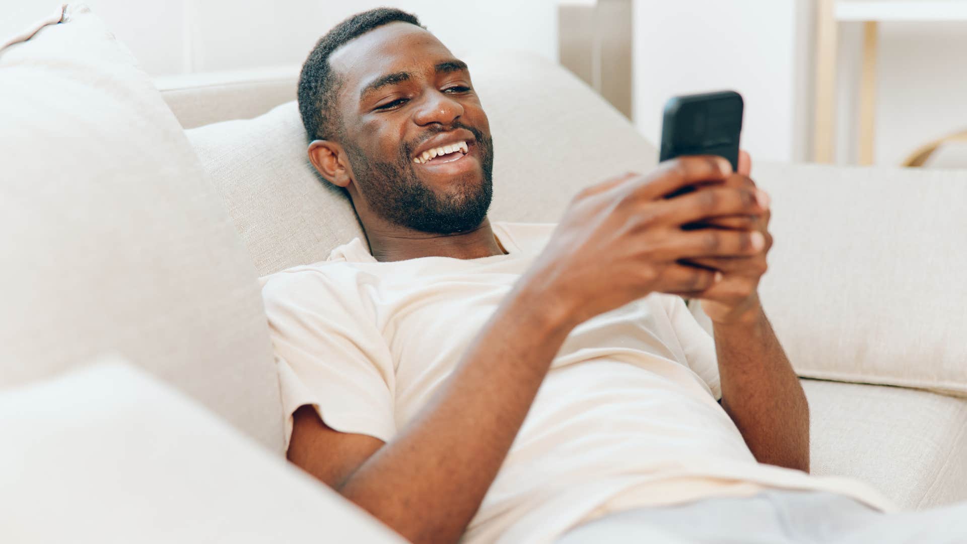man on his phone sending memes as a love language