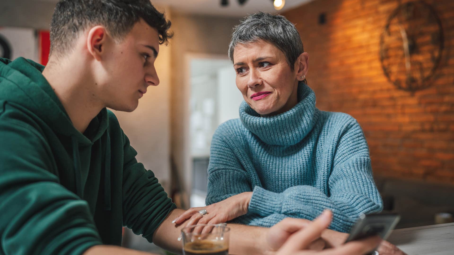 woman sitting with her adult son and talking down to him
