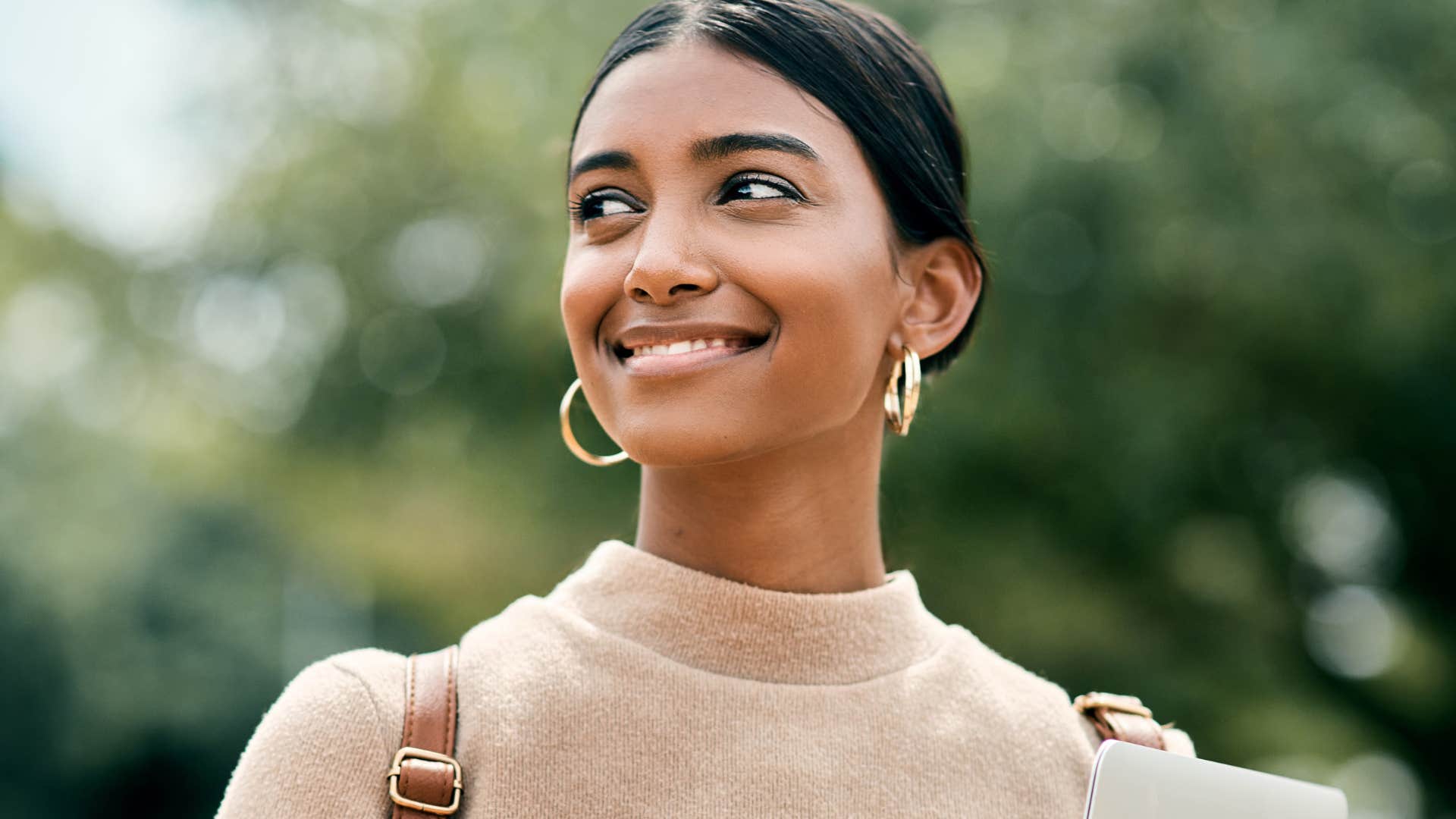 woman smiling while daydreaming outside