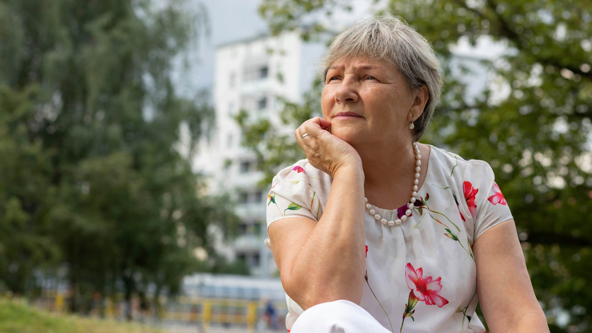 older woman thinking while sitting outside
