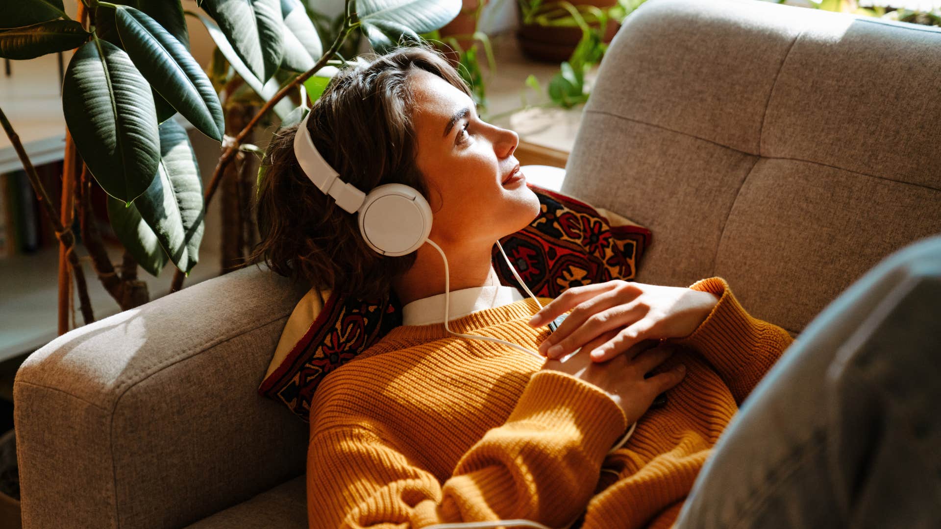 woman listening to music laying on couch