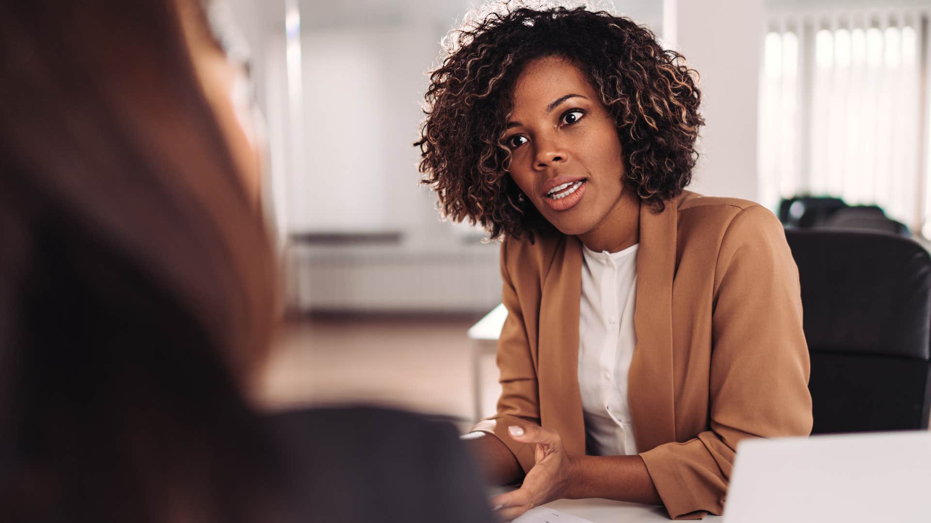 Upset woman being told what to do at work.